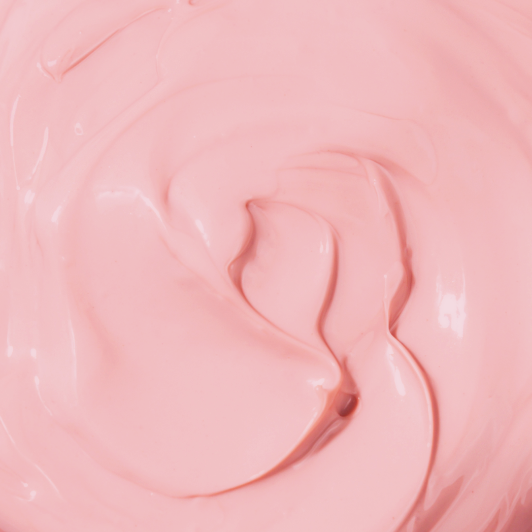 Baby pink coloured close up of body cream